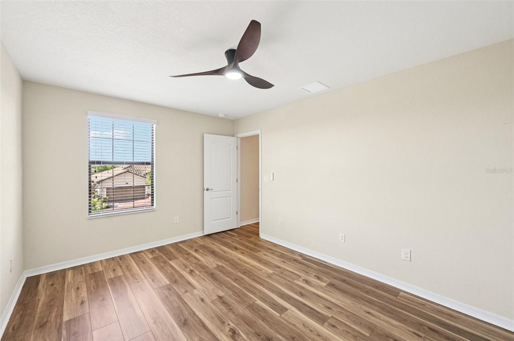 12680 Richezza Drive Venice, FL 34293 - Photo 19 of 57 a view of an empty room with wooden floor and a window