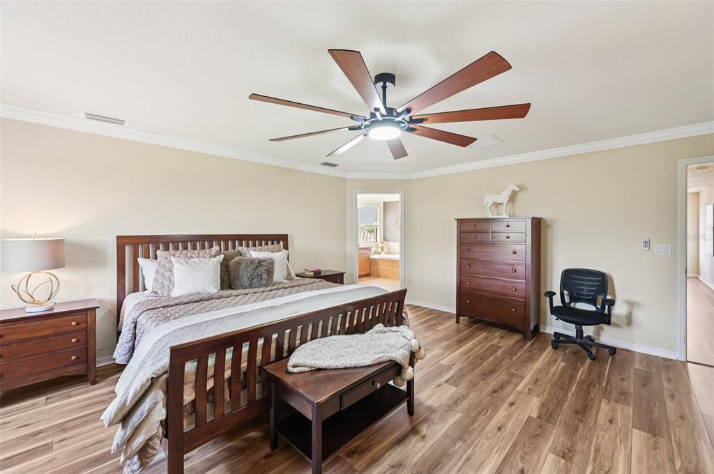 12680 Richezza Drive Venice, FL 34293 - Photo 28 of 57 a bedroom with a bed and a chandelier