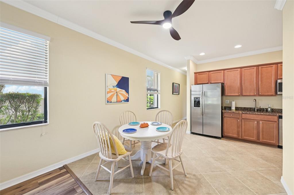 12680 Richezza Drive Venice, FL 34293 - Photo 38 of 57 a dining room with stainless steel appliances kitchen island granite countertop a dining table and chairs with wooden floor