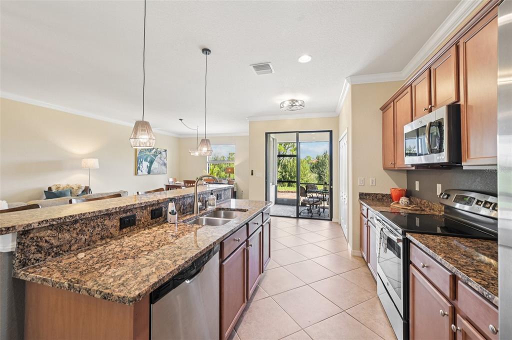 12680 Richezza Drive Venice, FL 34293 - Photo 10 of 57 a kitchen with kitchen island granite countertop a sink and a wooden floor