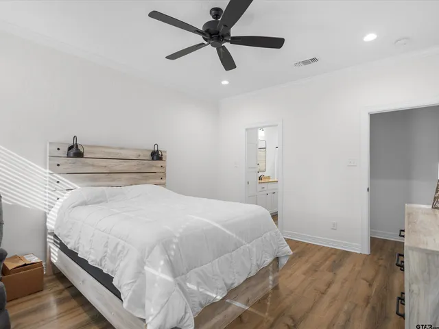 a bedroom with a bed and a ceiling fan