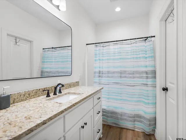 a bathroom with a granite countertop sink and a mirror
