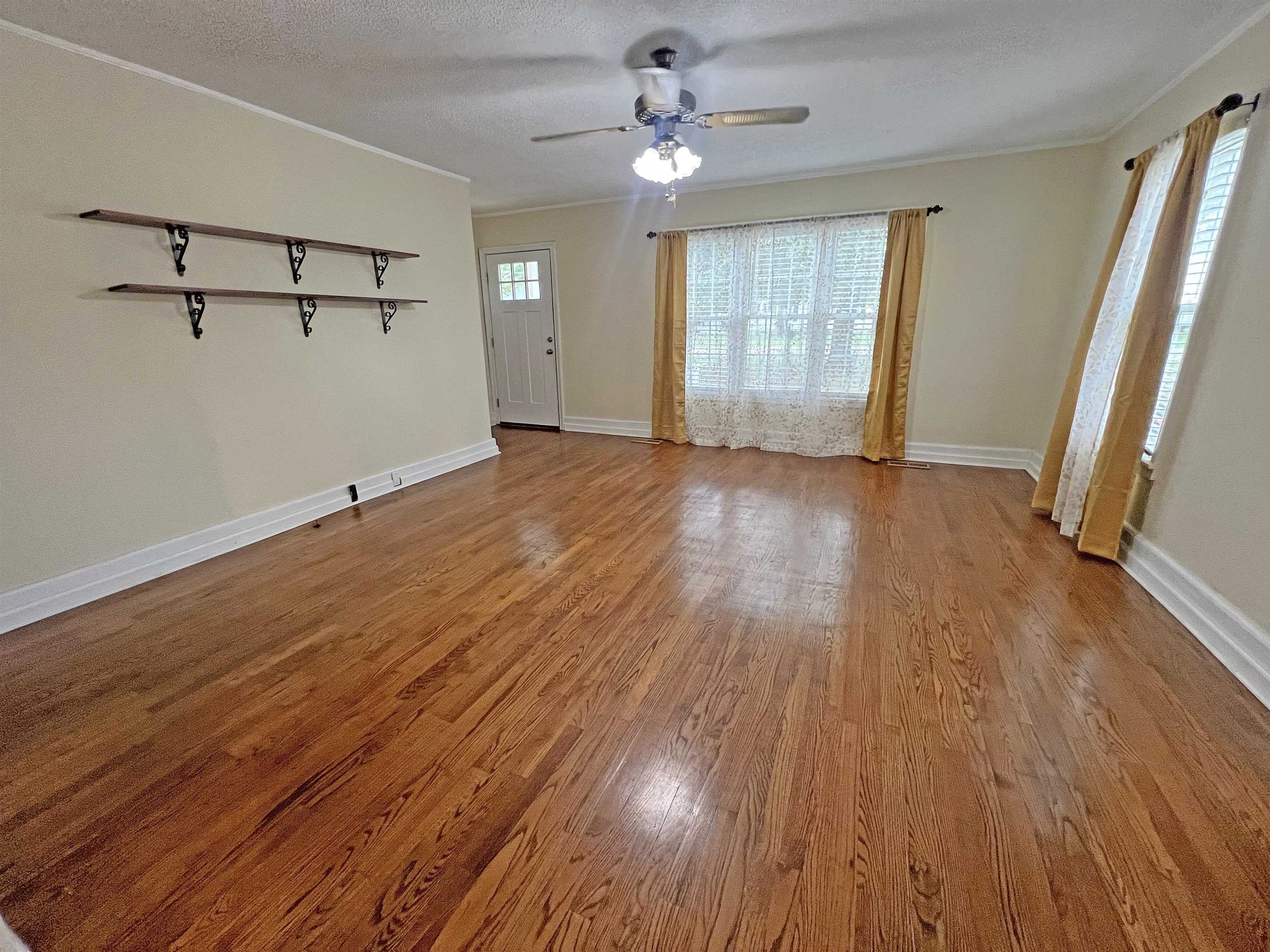 300 Patterson Road Savannah, TN 38372 - Photo 6 of 30 an empty room with wooden floor and windows