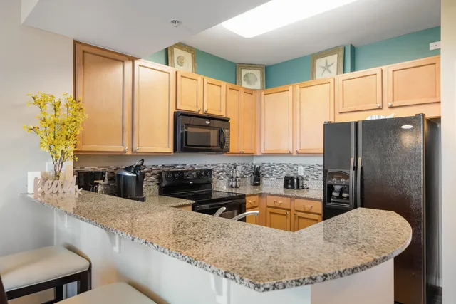 a kitchen with stainless steel appliances granite countertop a refrigerator stove and sink
