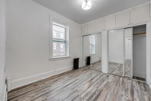 a view of empty room with wooden floor