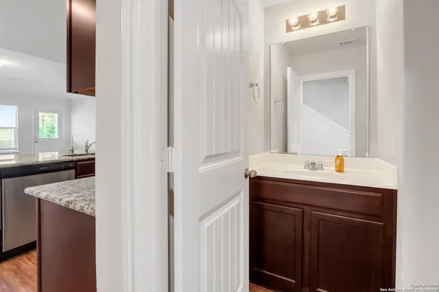 a bathroom with a granite countertop sink and a mirror