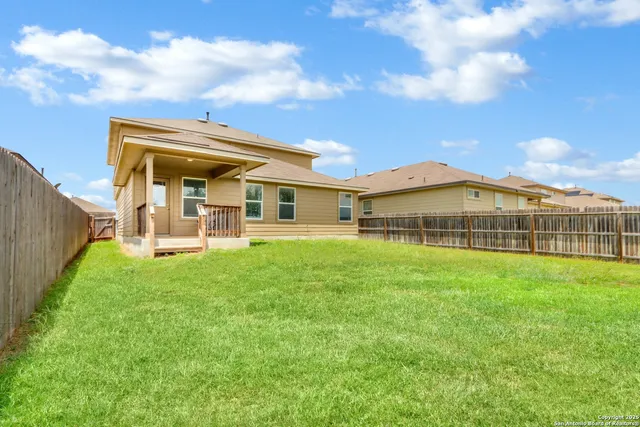 a view of a big house with a big yard and large trees