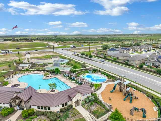 an aerial view of residential houses with outdoor space and swimming pool