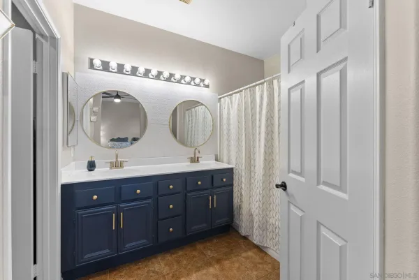 a bathroom with double vanity sink and a mirror