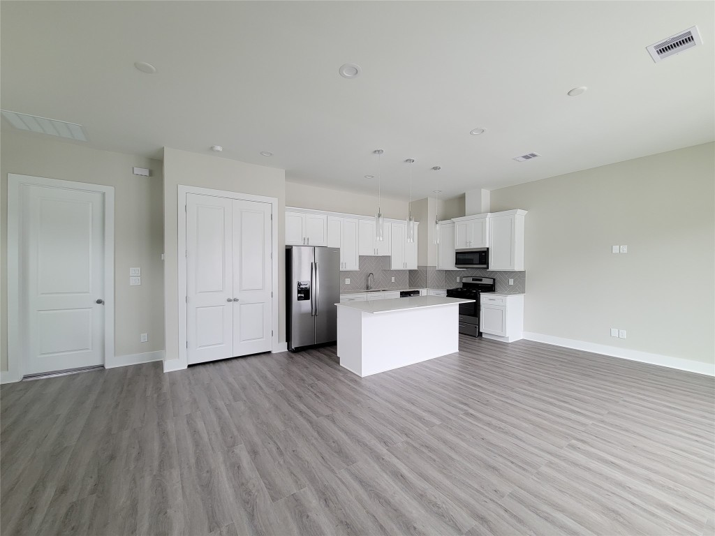 8316 Curry Road, Unit A Houston, TX 77093 - Photo 20 of 47 a kitchen with stainless steel appliances a refrigerator and wooden floor