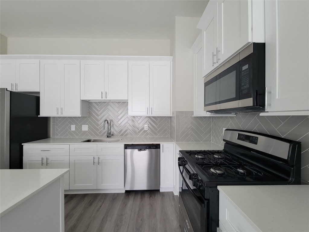 8316 Curry Road, Unit A Houston, TX 77093 - Photo 24 of 47 a kitchen with stainless steel appliances a stove a microwave a sink and cabinets