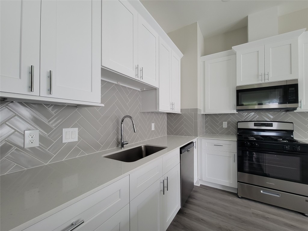 8316 Curry Road, Unit A Houston, TX 77093 - Photo 29 of 47 a kitchen with white cabinets and stainless steel appliances