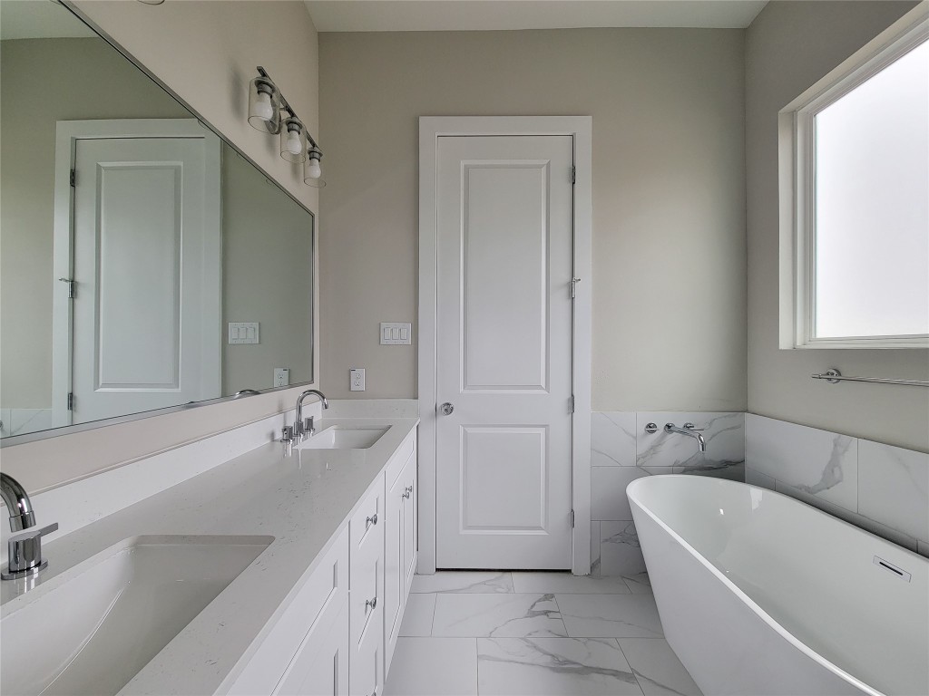 8316 Curry Road, Unit A Houston, TX 77093 - Photo 41 of 47 a bathroom with a tub a sink and mirror