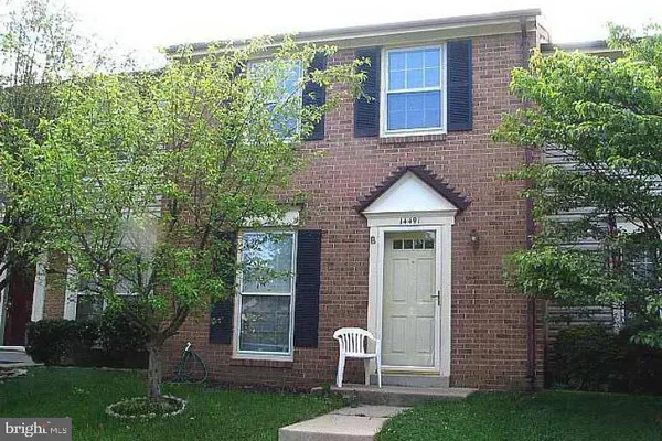 a brick house with a yard and table and chairs