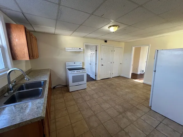 a kitchen with granite countertop a refrigerator and a sink