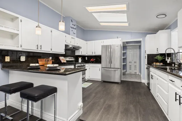 a kitchen with stainless steel appliances a stove a sink a microwave and cabinets