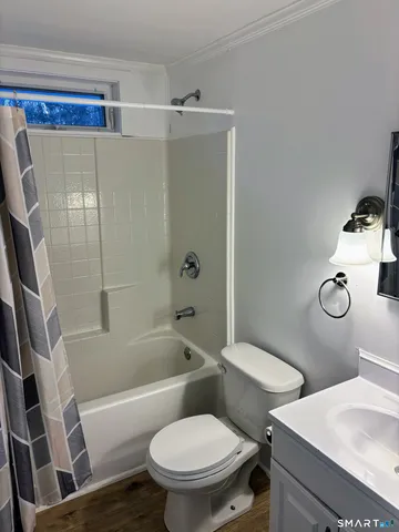 a white toilet sitting next to a bath tub