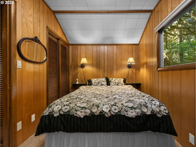 a bedroom with a bed and dresser with mirror