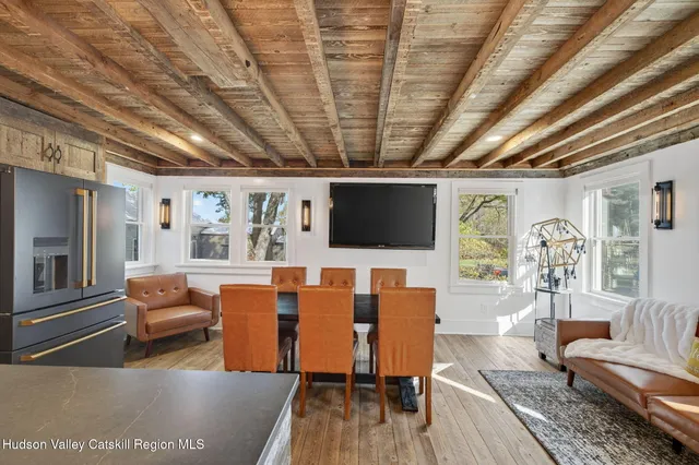 a living room with furniture a flat screen tv and kitchen view