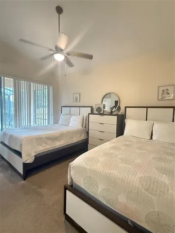 a bedroom with two bed and a painting on the wall