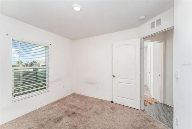 an empty room with windows and closet