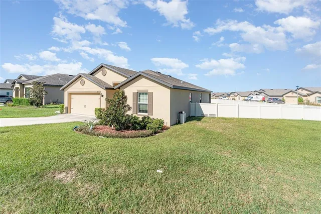 a view of a house with a yard and garage