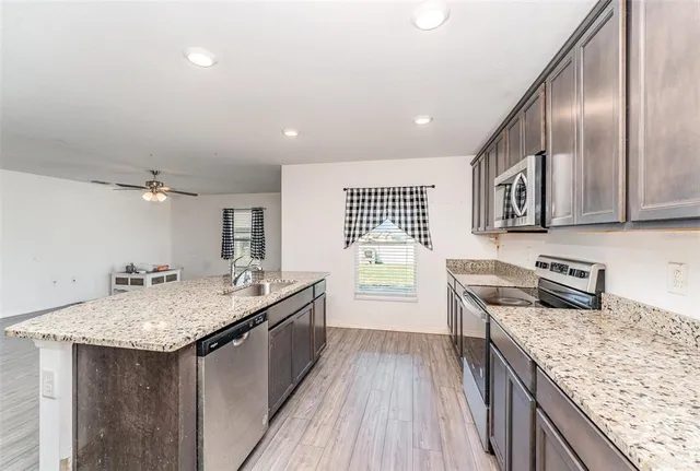 a kitchen with stainless steel appliances granite countertop a sink stove and refrigerator