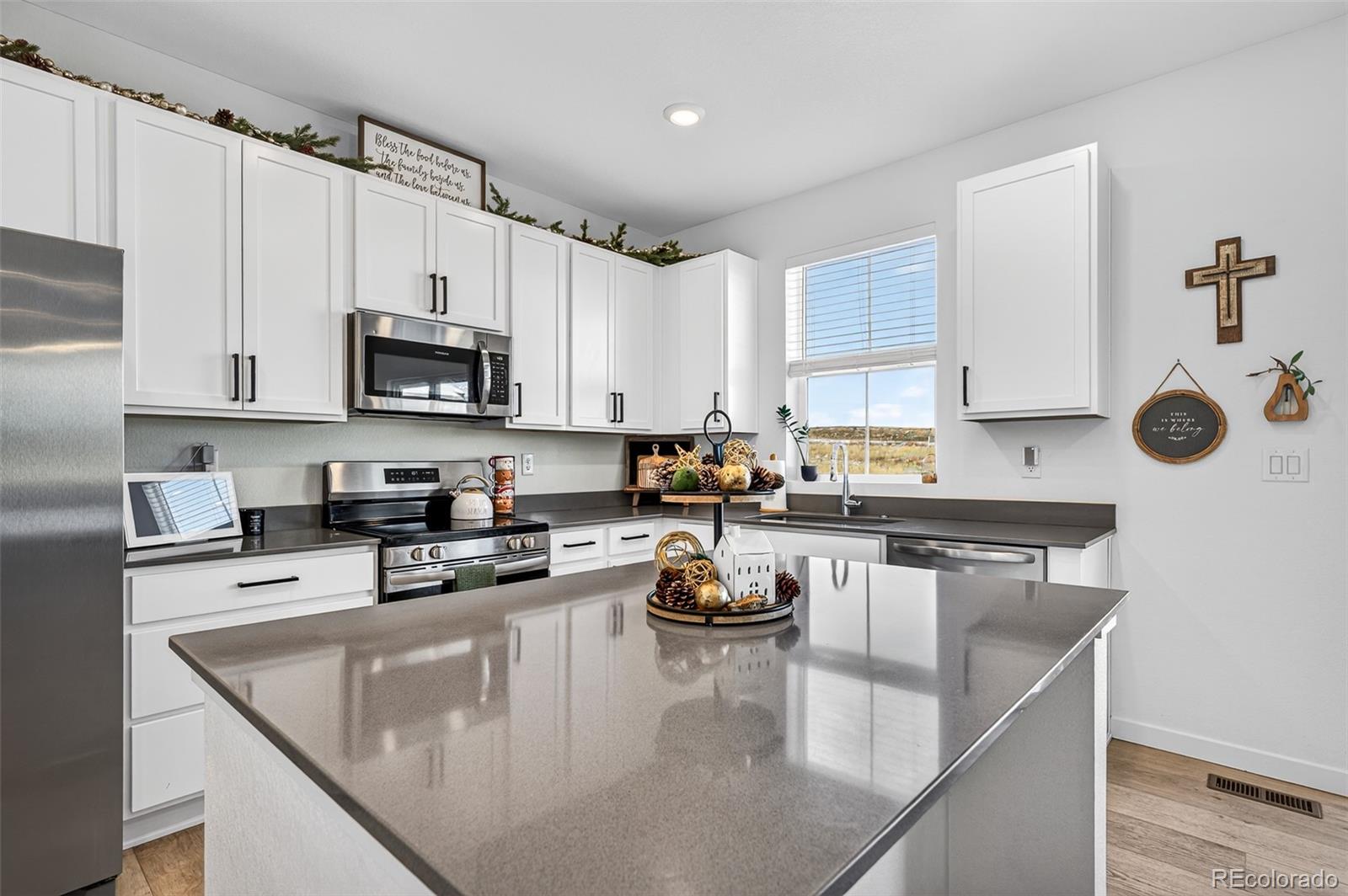 233 Corkscrew Street Elizabeth, CO 80107 - Photo 14 of 33 a kitchen with stainless steel appliances granite countertop a sink a stove and microwave