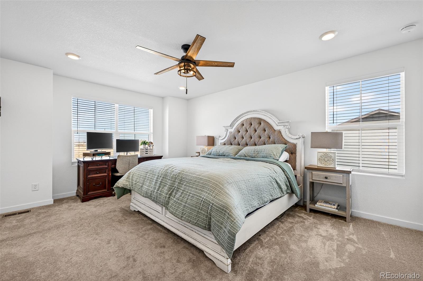 233 Corkscrew Street Elizabeth, CO 80107 - Photo 18 of 33 a spacious bedroom with a bed a dresser and a chandelier