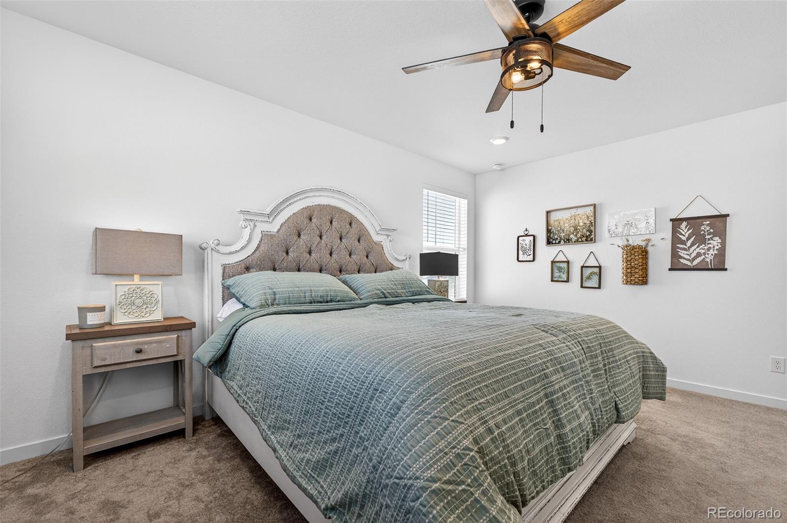 233 Corkscrew Street Elizabeth, CO 80107 - Photo 7 of 33 a bedroom with a bed and ceiling fan