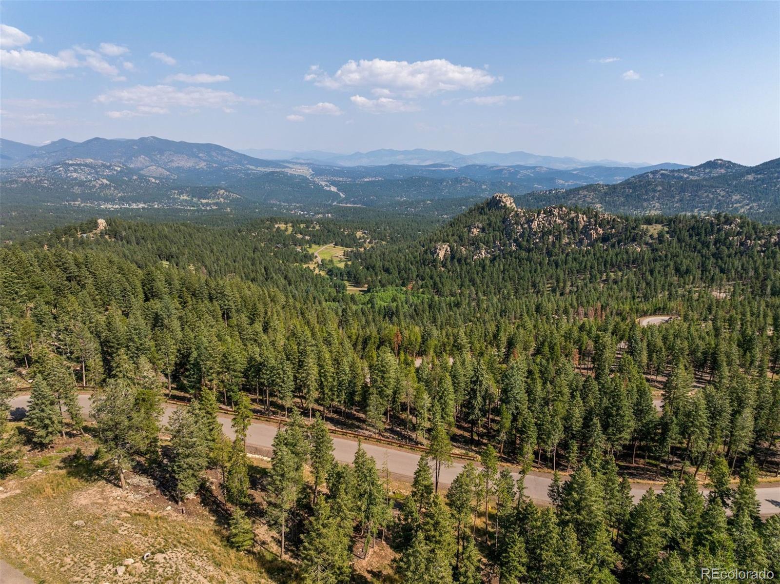 6371 Canyon Creek Road Evergreen, CO 80439 - Photo 7 of 50 a view of a lush green field with mountains in the background