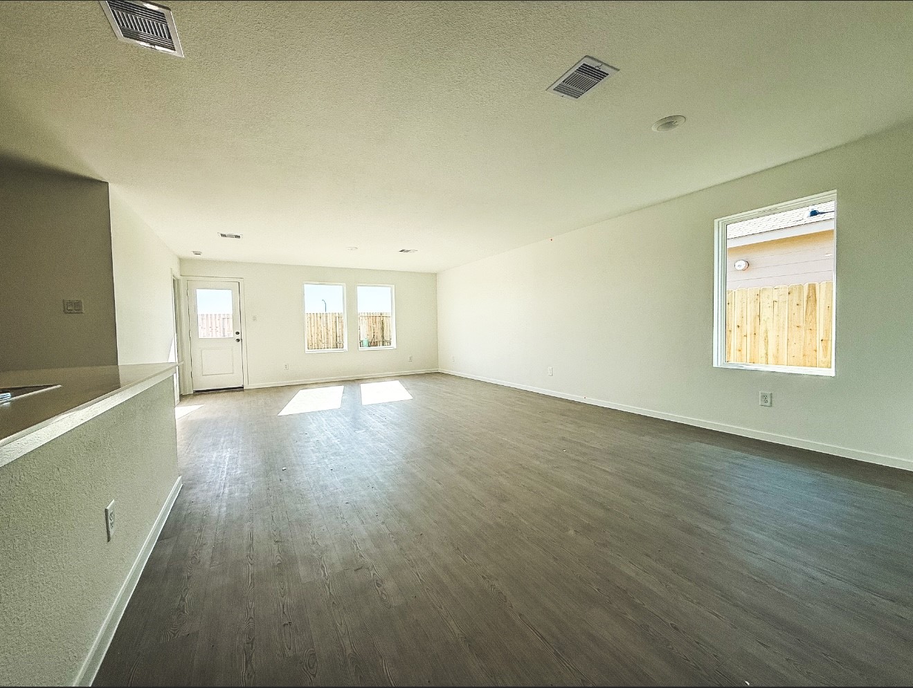 316 Nicholas Road Wharton, TX 77488 - Photo 5 of 9 an empty room with wooden floor and windows