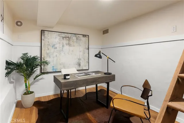 a view of a workspace room with furniture and window