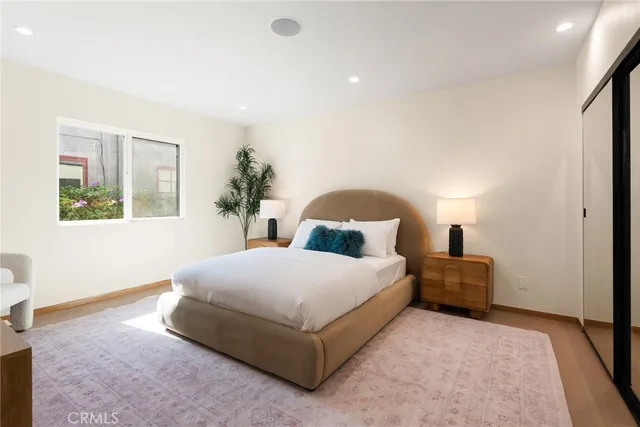 a bedroom with a bed lamp and a potted plant
