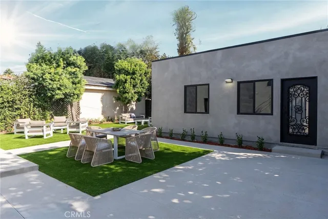 a view of backyard of house with outdoor seating