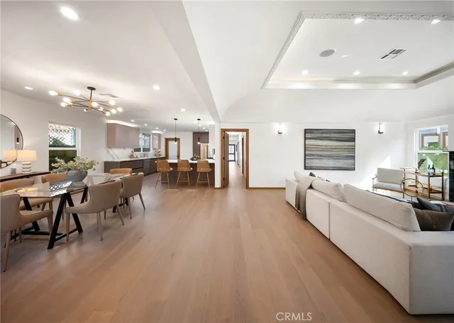 a large white kitchen with lots of furniture and chandelier
