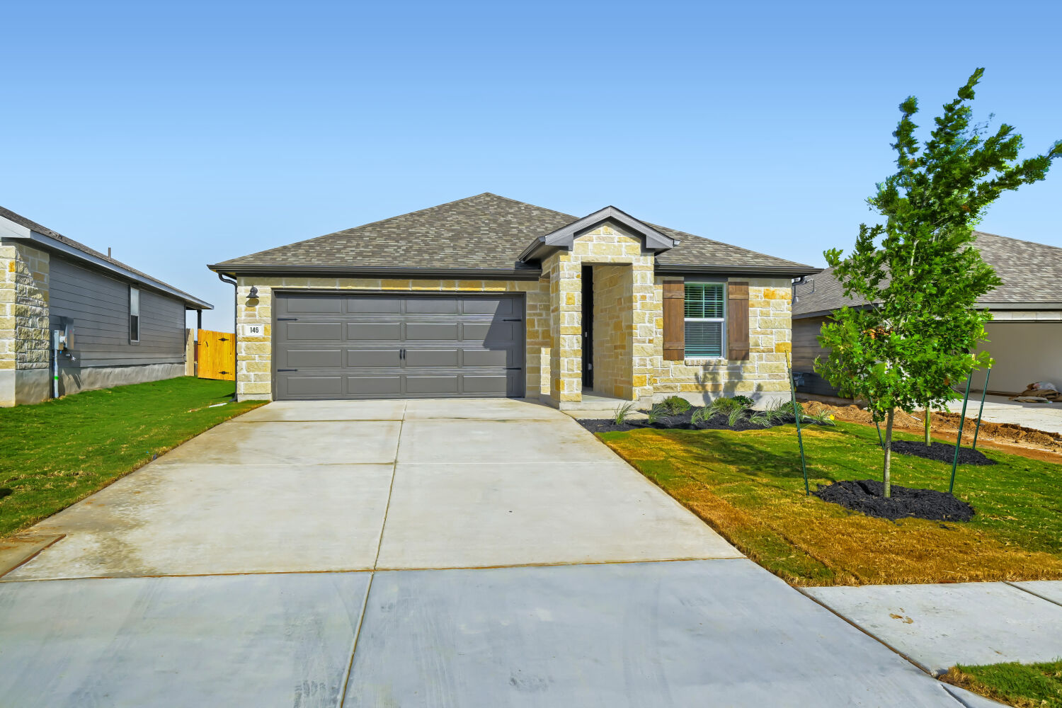 146 Diablo Rim Terrace Dripping Springs, TX 78620 - Photo 7 of 32 A well-maintained lawn and sturdy stone facade enhance this inviting single-story home's curb appeal.