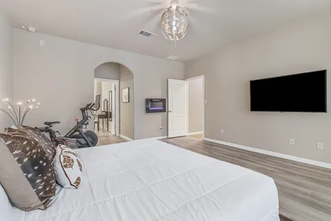 a bedroom with a bed and a flat tv screen on dresser
