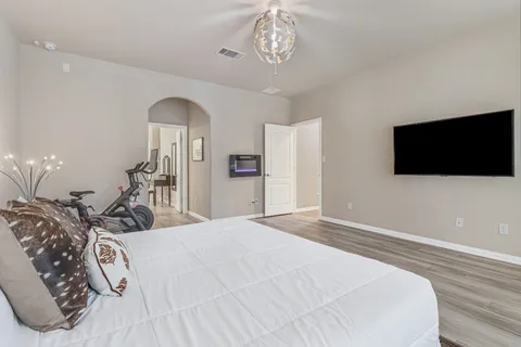 a bedroom with a bed and a flat tv screen on dresser