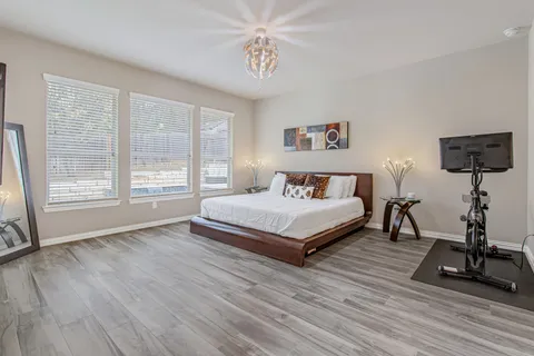 a bedroom with a bed and wooden floor