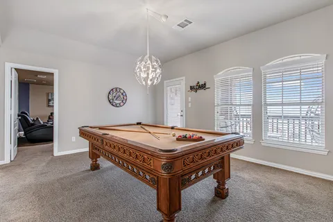 a room with pool table and windows