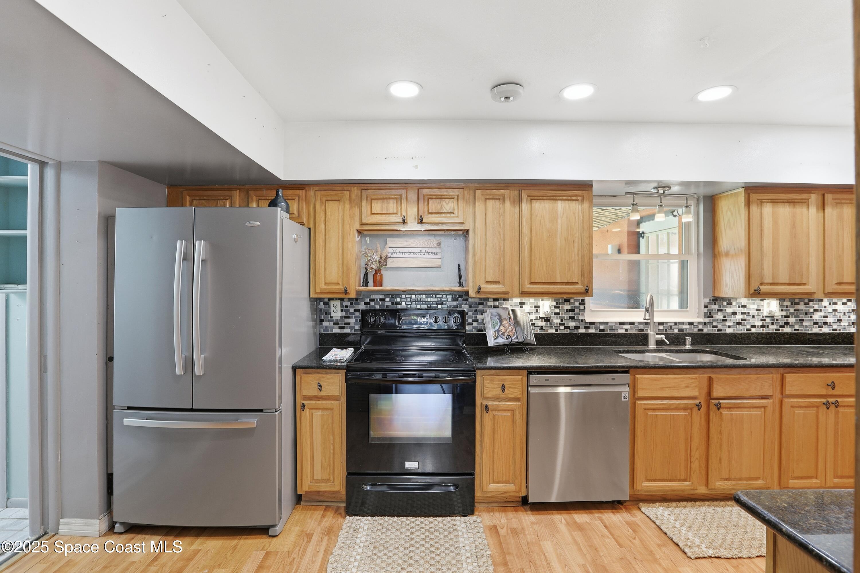 3929 Burkholm Road Mims, FL 32754 - Photo 12 of 51 a kitchen with stainless steel appliances granite countertop a refrigerator a stove and a sink