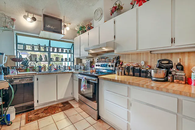 a kitchen filled with stainless steel appliances granite countertop a sink and cabinets