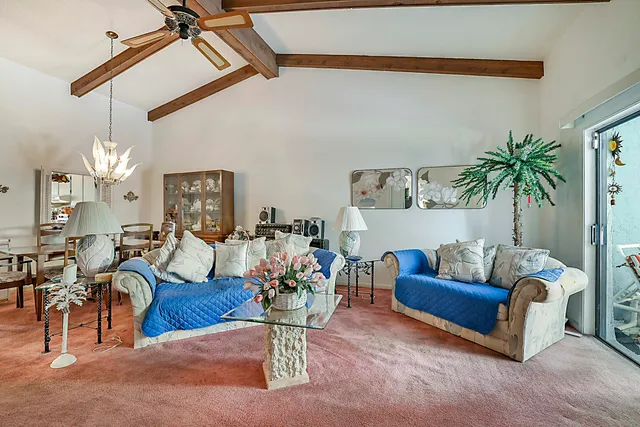 a living room with furniture kitchen view and a chandelier