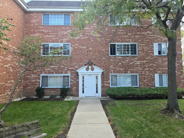 a front view of a house with a garden and yard