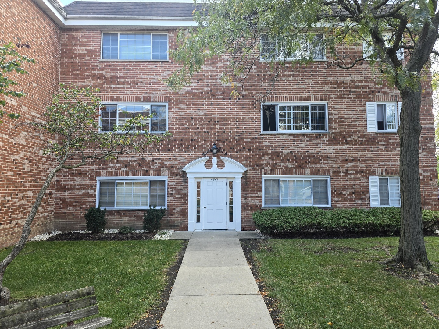 6882 West Touhy Avenue, Unit D Niles, IL 60714 - Photo 1 of 9 a front view of a house with a garden and yard