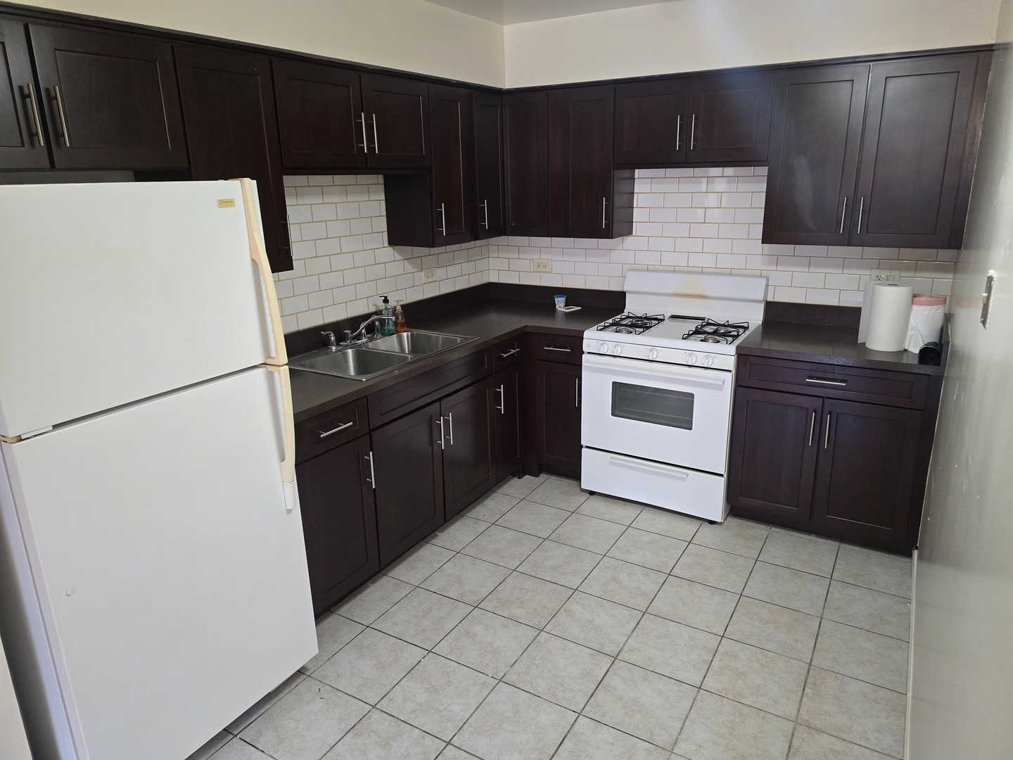 6882 West Touhy Avenue, Unit D Niles, IL 60714 - Photo 3 of 9 a kitchen with a stove top oven and cabinets