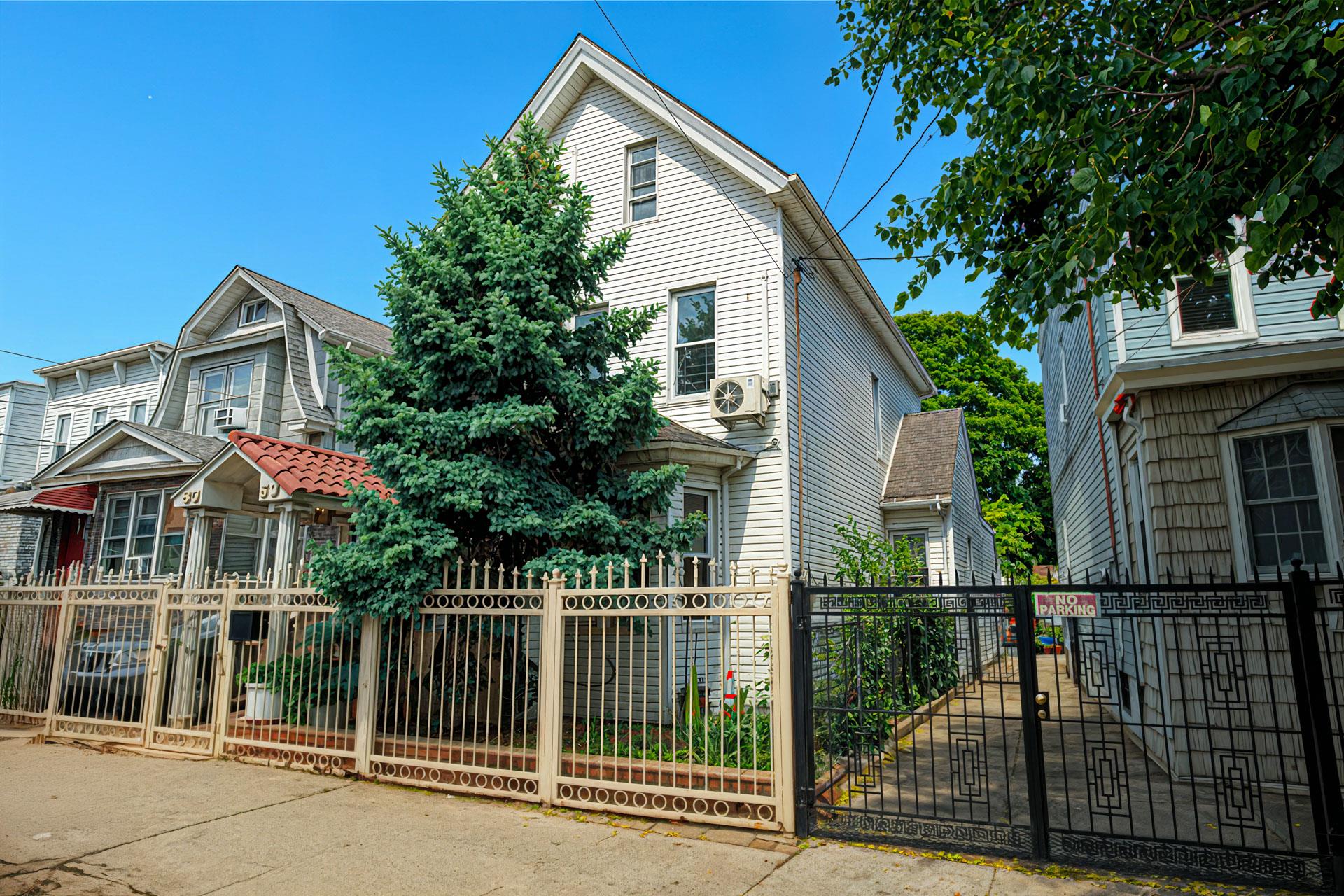 80-63 87th Road Queens, NY 11421 - Photo 2 of 24 a front view of a house with a garden