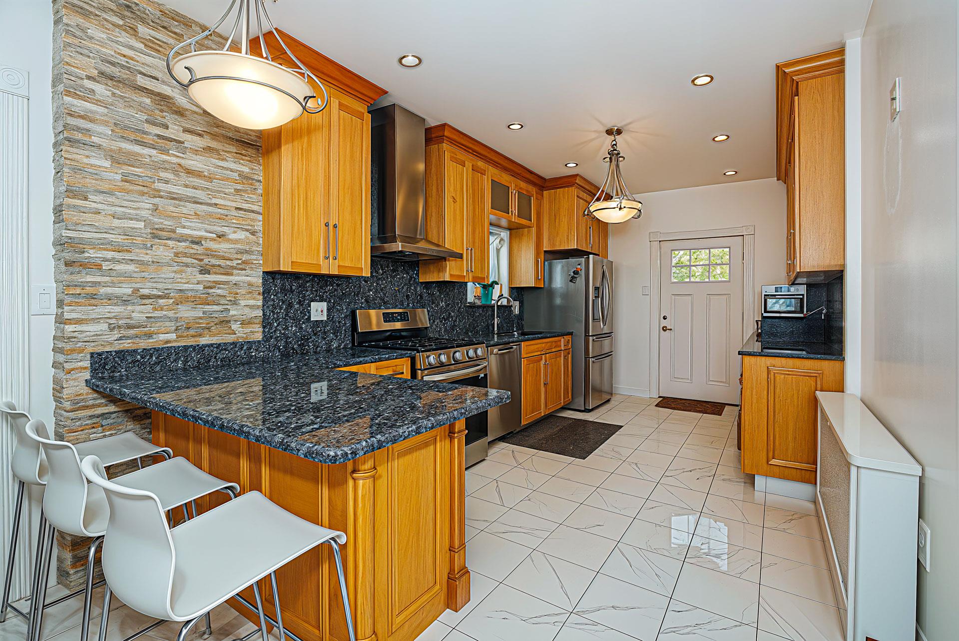 80-63 87th Road Queens, NY 11421 - Photo 6 of 24 a kitchen with stainless steel appliances granite countertop a stove a sink and a microwave