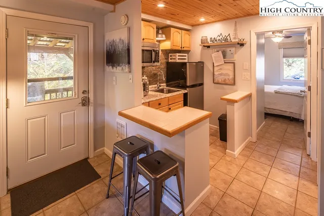 a kitchen with stainless steel appliances granite countertop a refrigerator a stove and a sink with large cabinets